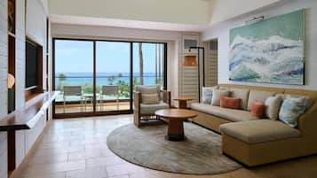A modern living room with a sofa, chairs, a coffee table, and a large painting.