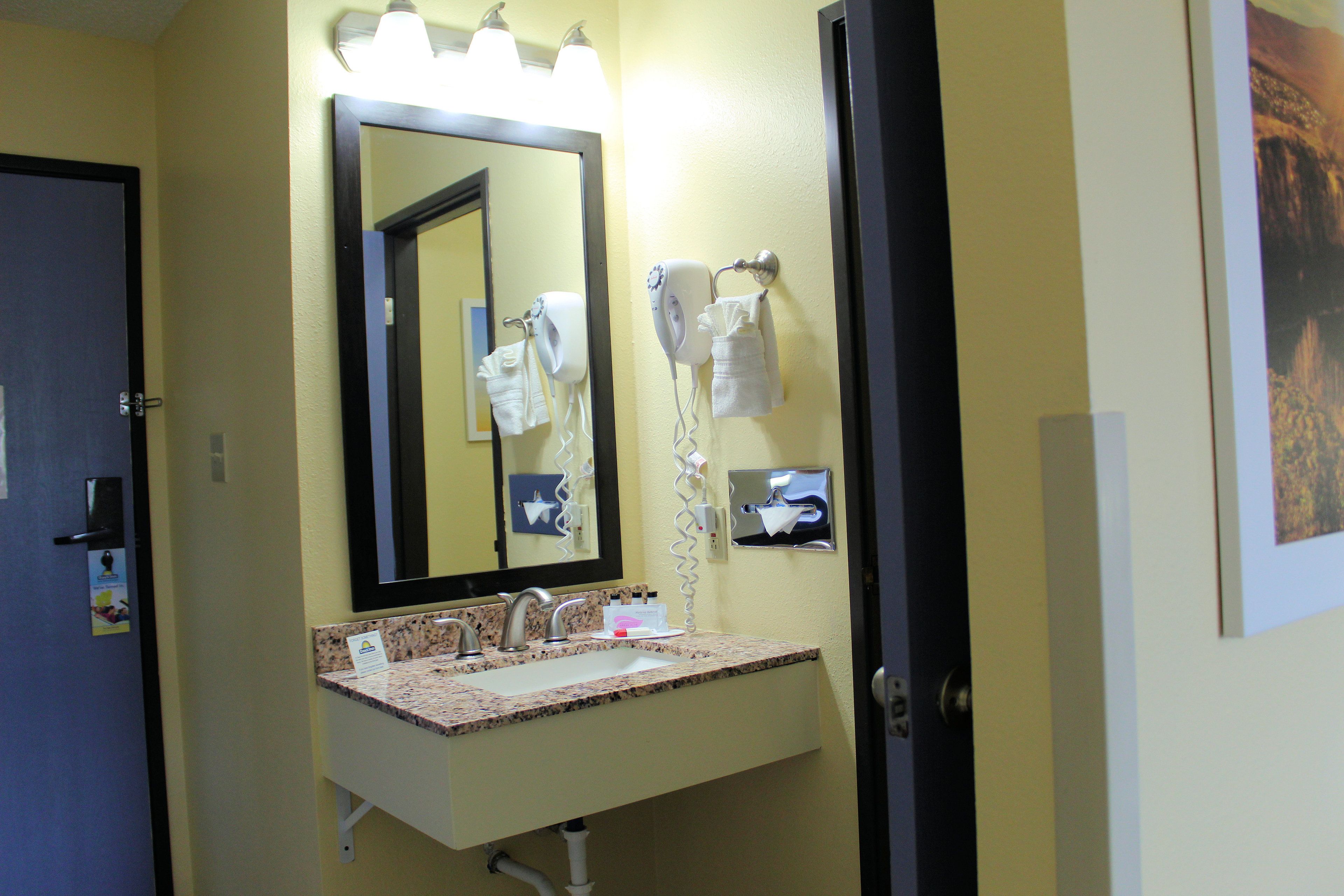 A bathroom with a sink, mirror, towel rack, and hairdryer.