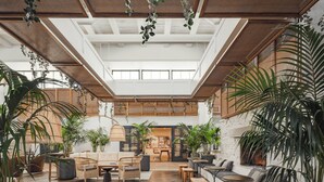 A spacious indoor area with high ceilings, wooden flooring, and various seating arrangements including sofas and chairs. - The Scott Resort & Spa  (Scottsdale)