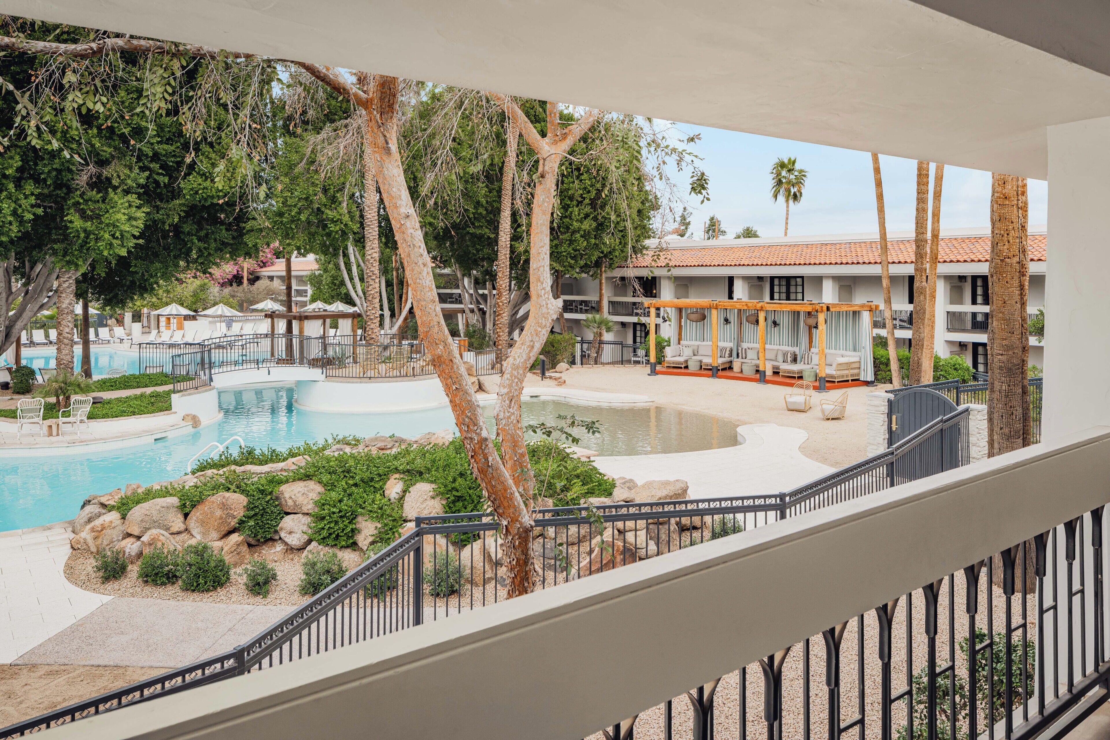 A hotel with a pool, outdoor seating, and a view of the surrounding area.