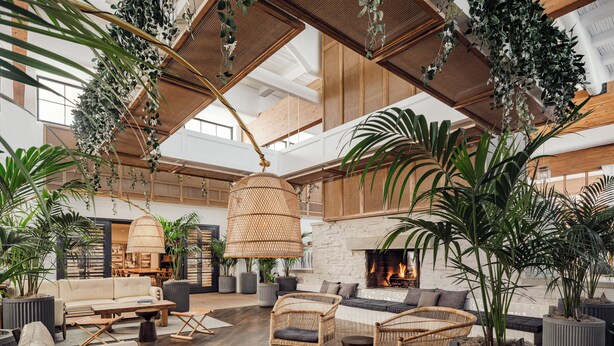A spacious living area with a fireplace, comfortable seating, and lush greenery. - The Scott Resort & Spa  (Scottsdale)