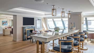A modern kitchen with a central island, bar stools, and pendant lighting.