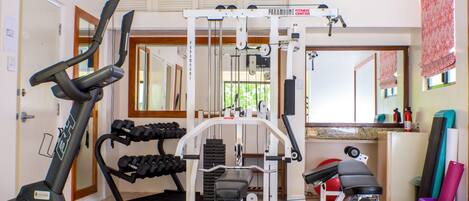 A gym with exercise equipment including a treadmill, weight machines, and dumbbells.
