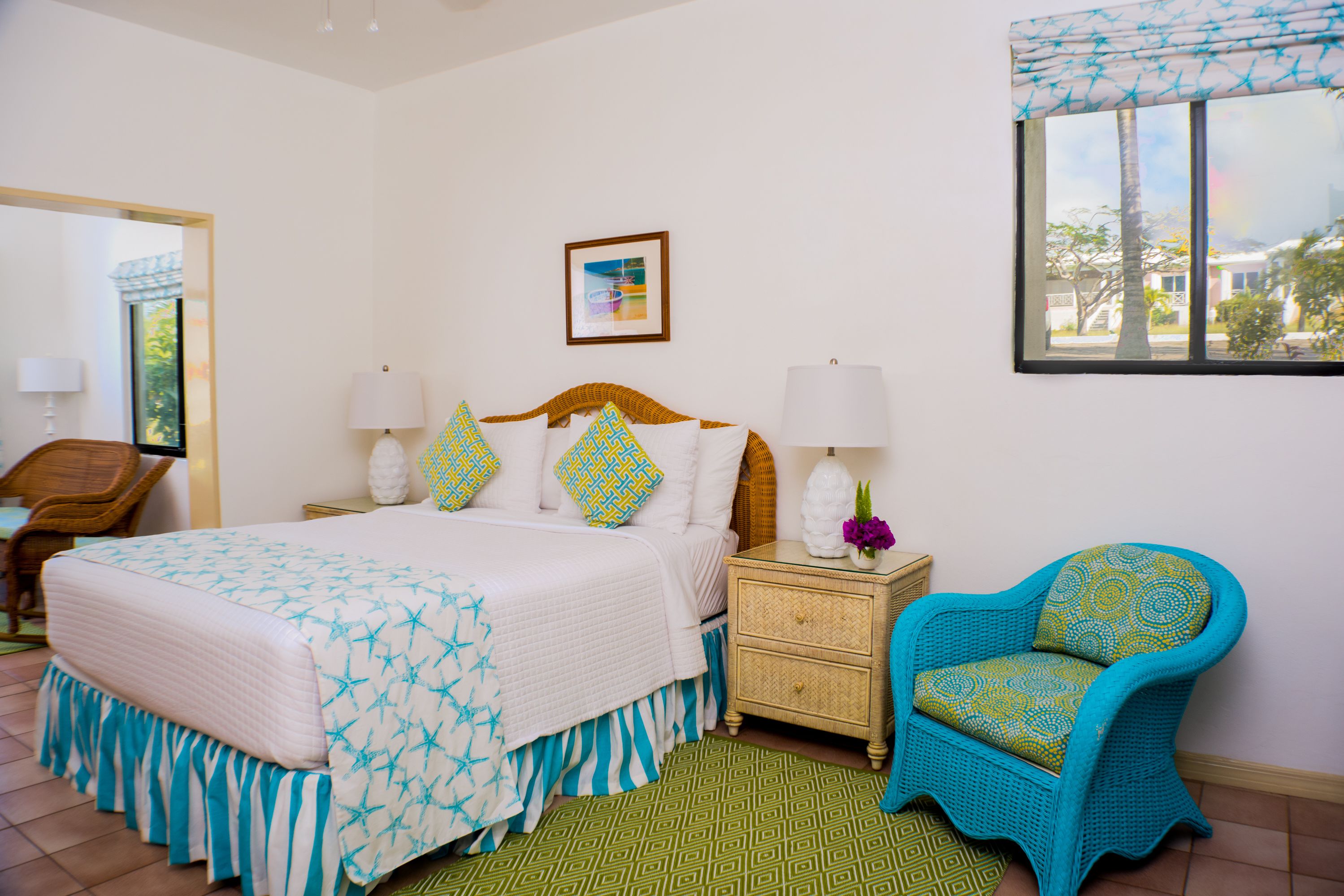 A bedroom with a bed, nightstand, chair, and a window with a view.