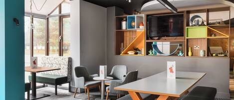 A modern interior with a dining area, seating, and a TV.