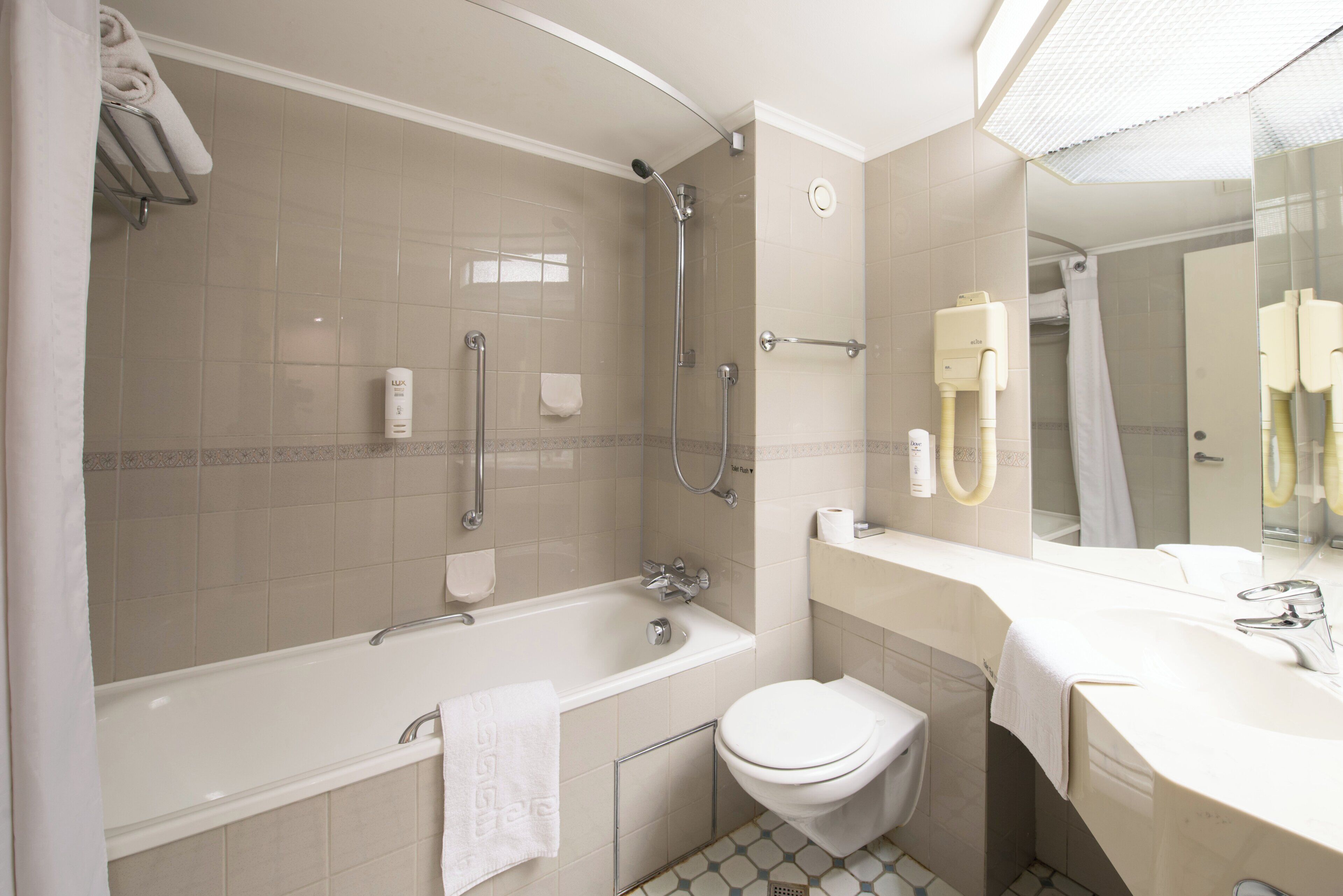 Un baño moderno con bañera, inodoro y ducha.