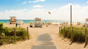 A beach pathway leading to beach umbrellas and lounge chairs. - YVE Hotel Miami (Miami)