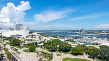 Una zona urbana moderna con un puerto deportivo, un edificio blanco grande y un puente.