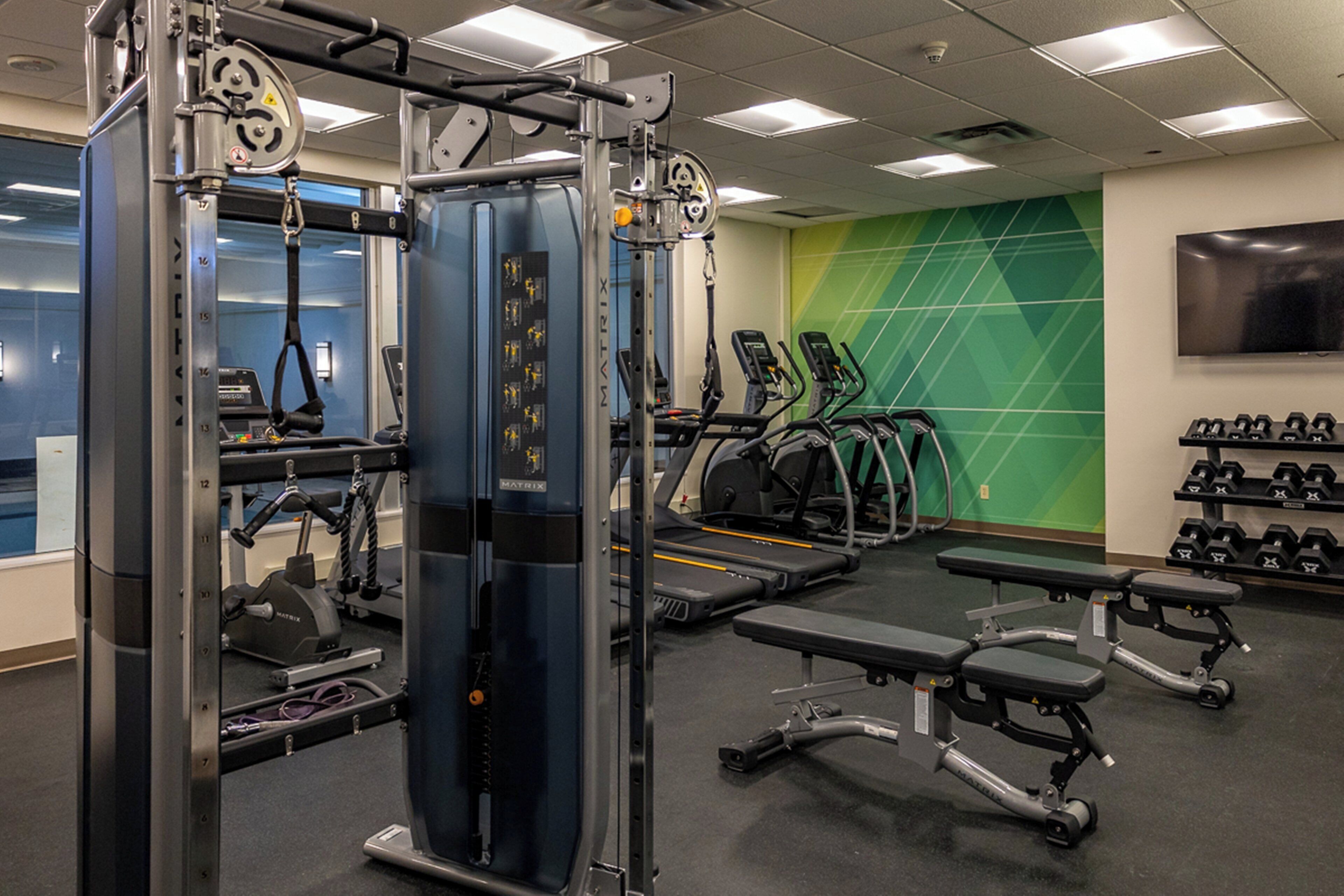 A gym with exercise equipment, treadmills, and benches.