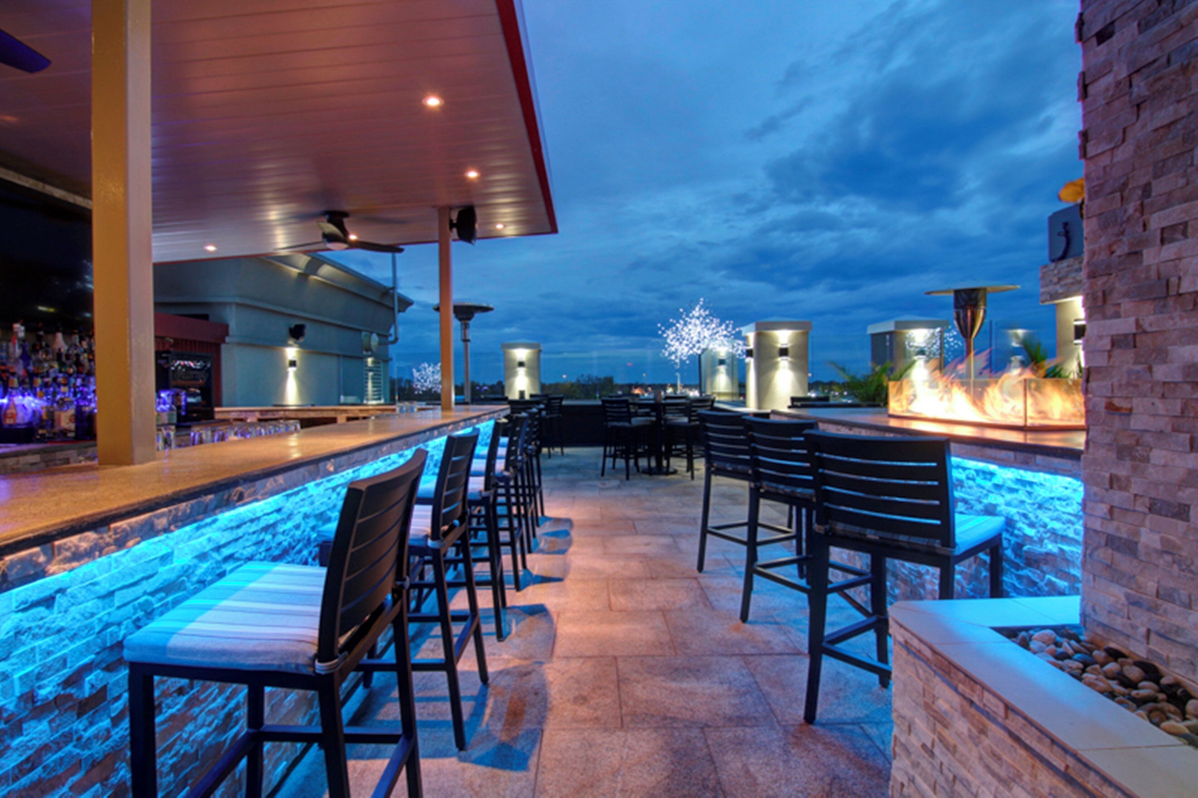 Un espace bar extérieur avec des sièges et une vue sur la piscine.