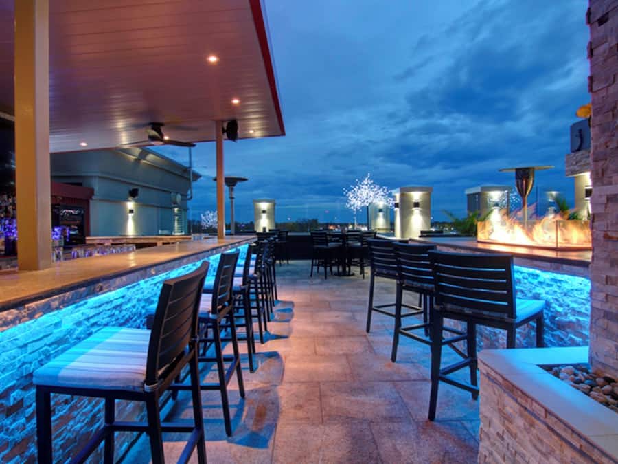 An outdoor bar area with seating and a poolside view.