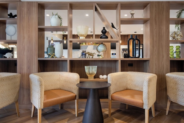 A modern interior with wooden shelving, patterned chairs, and a central table.