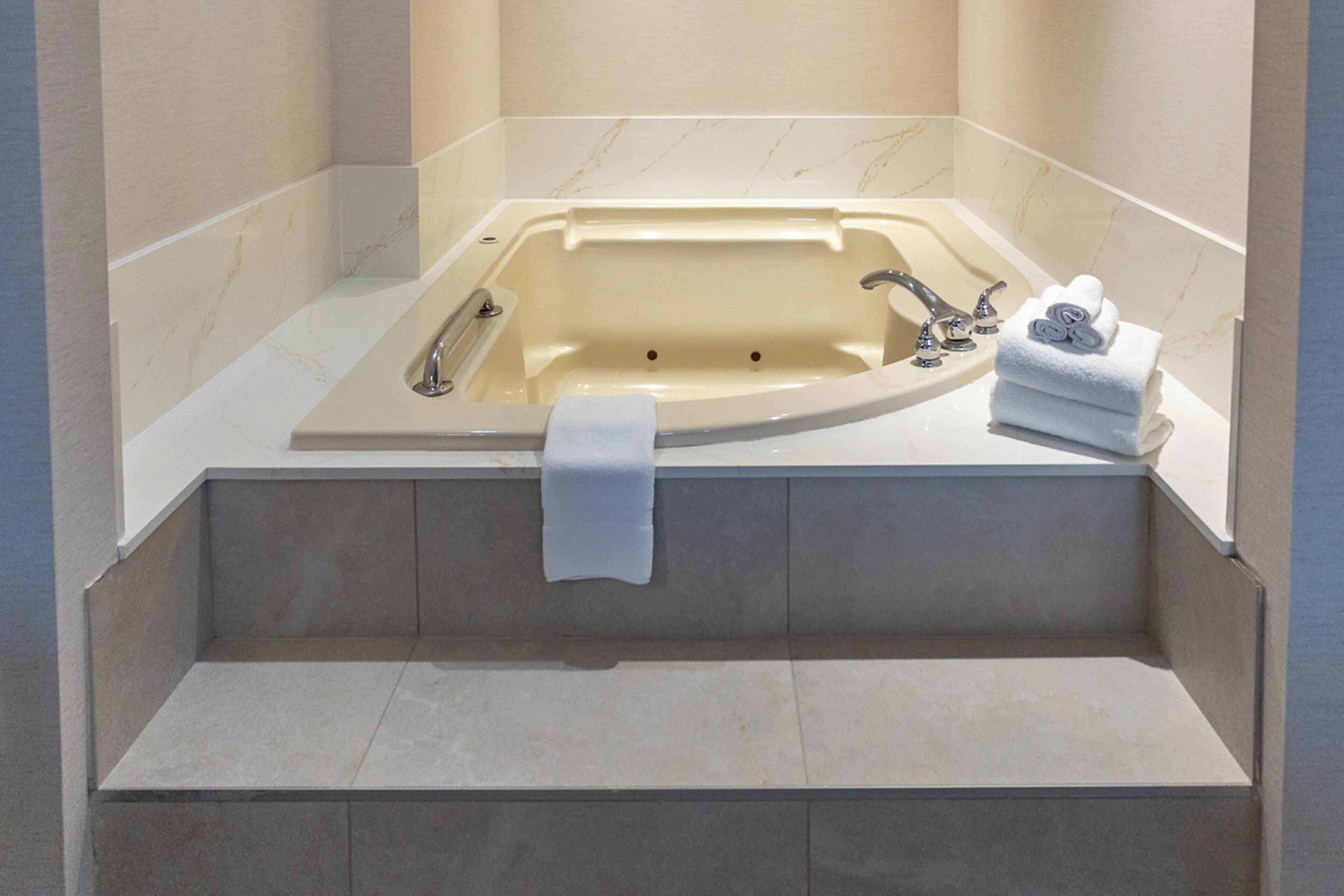 Une salle de bain moderne avec une baignoire îlot, une douche intégrée et un meuble-lavabo doté d’un porte-serviettes.