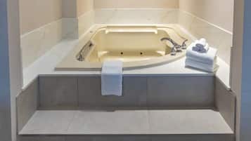 A modern bathroom with a freestanding bathtub, a built-in shower, and a vanity with a towel rack.