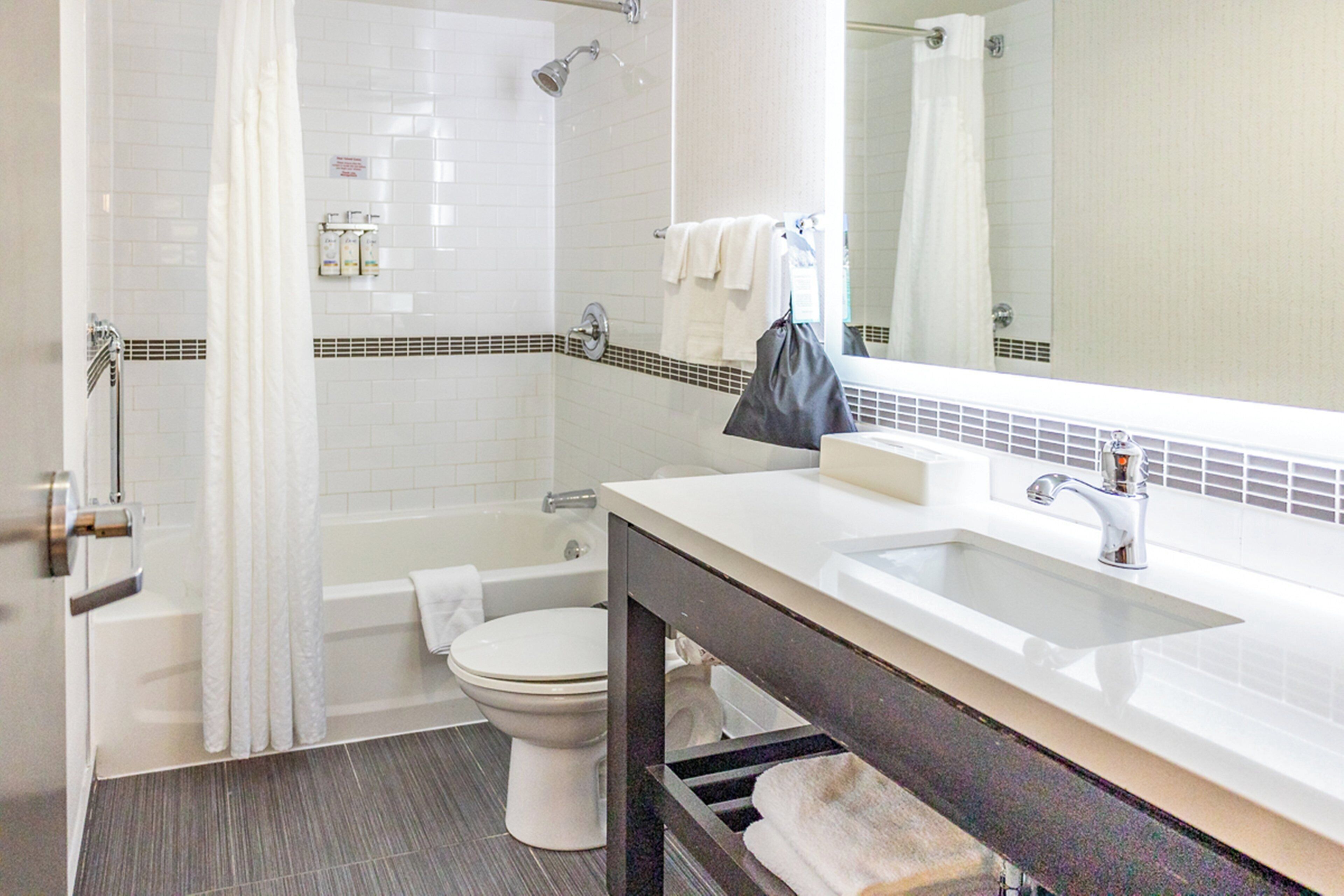 Ein modernes Badezimmer mit Badewanne, Toilette und Waschbecken.