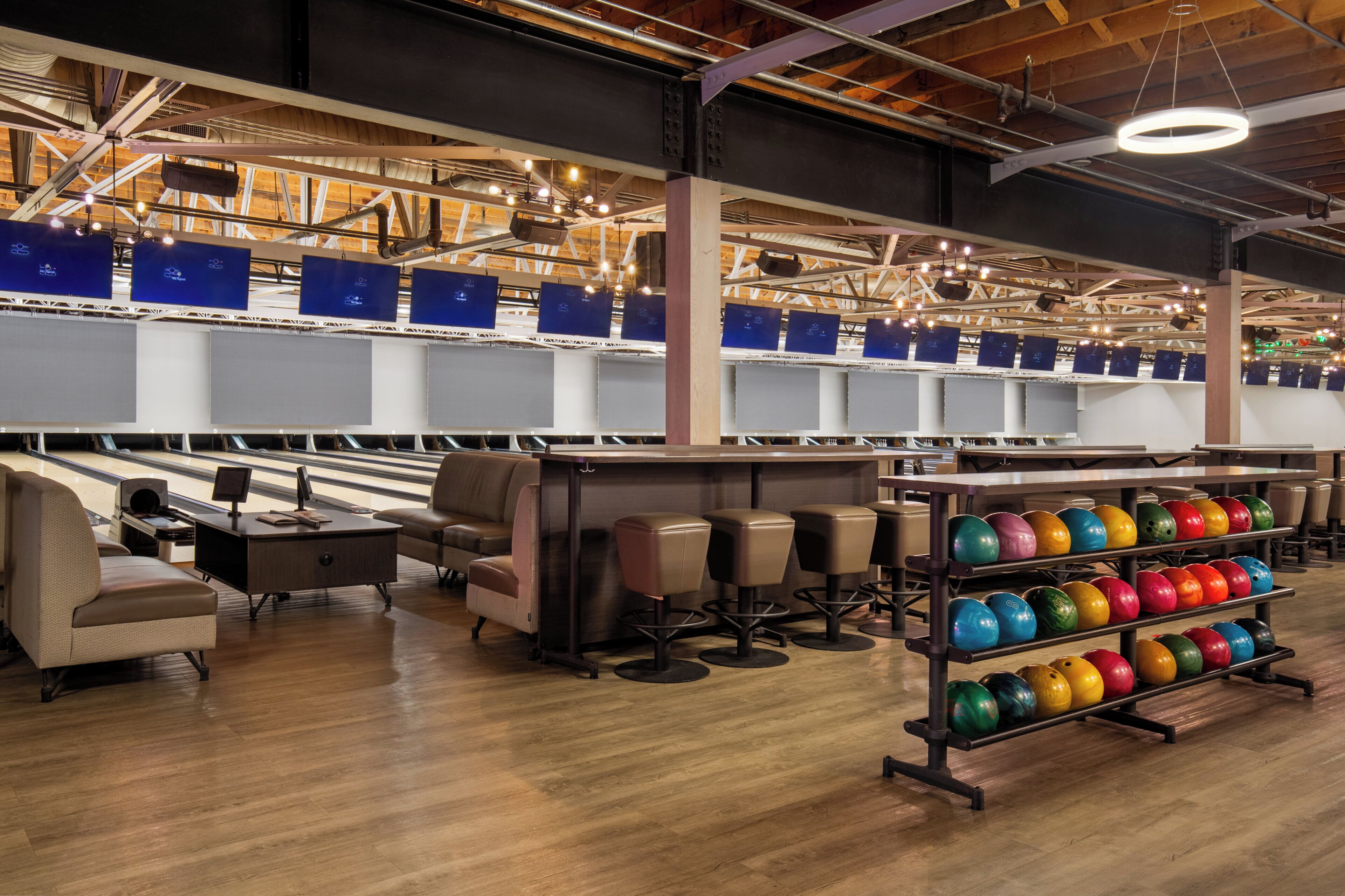 Una pista da bowling con diverse corsie, zone relax e un carrello per le bocce.