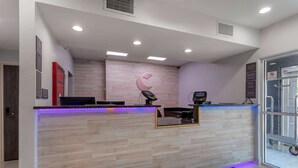 A reception area with a wooden reception desk, a digital screen, and a glass door leading outside. - Comfort Inn & Suites Memphis East (Memphis)