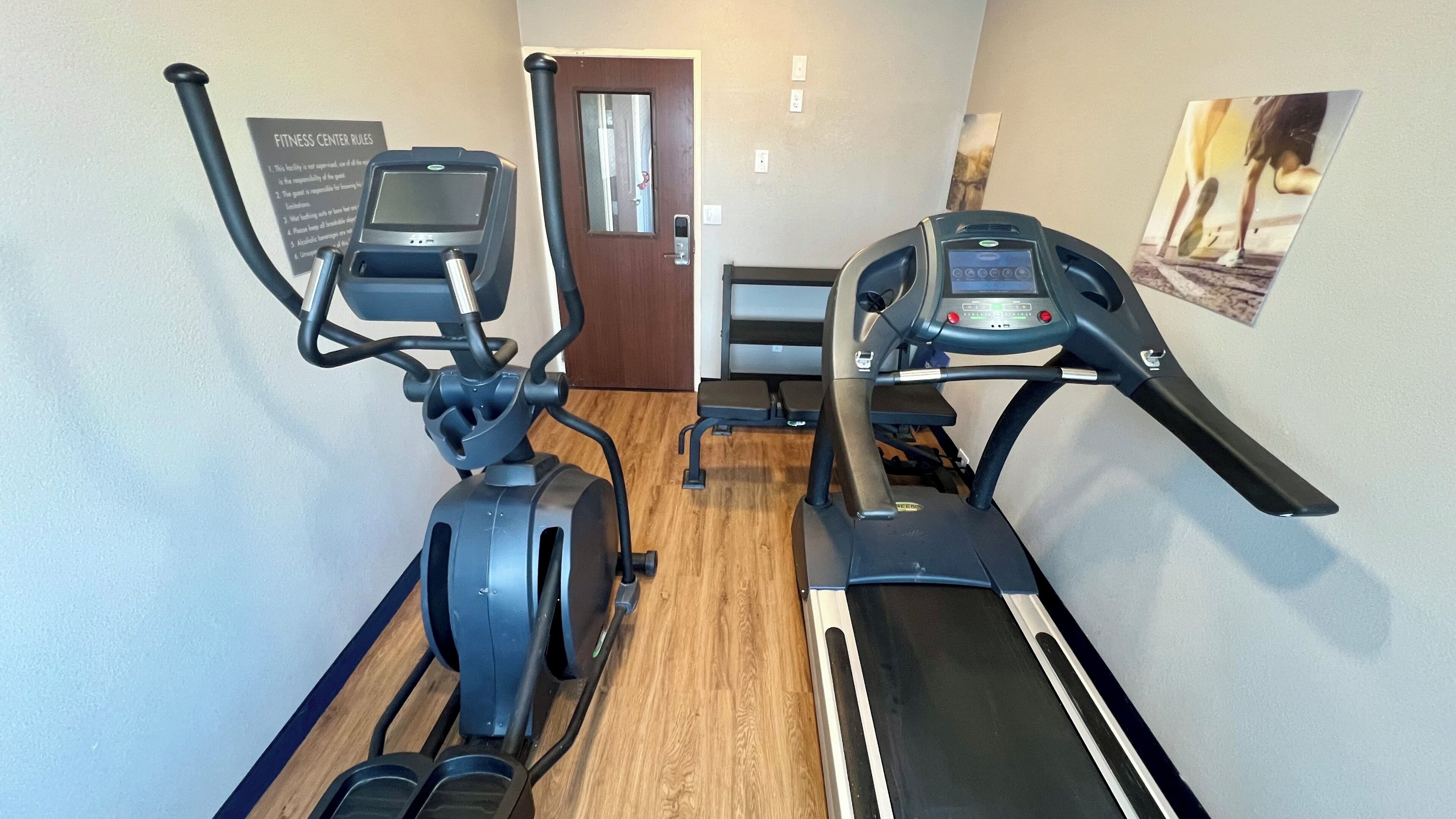 Un gimnasio con dos cintas de correr y una máquina elíptica.