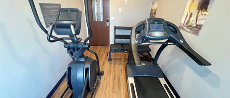Un gimnasio con dos cintas de correr y una máquina elíptica.