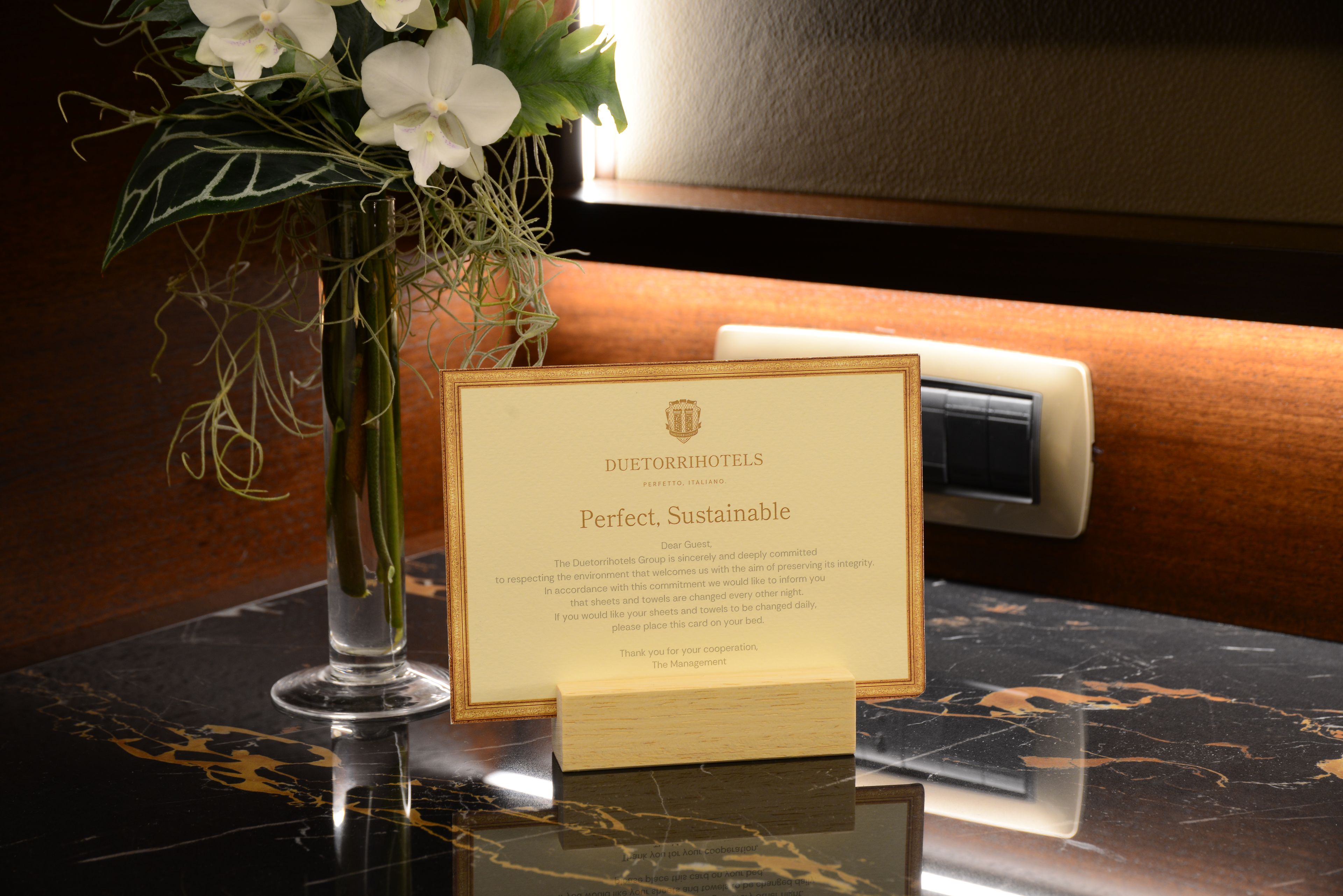 A card on a table with text about Duetori hotels' commitment to sustainability.