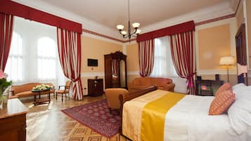 Une chambre d’hôtel comprenant un lit, un canapé, une chaise, un bureau et un miroir.