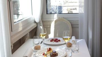 A dining table set with plates of food, glasses of wine, and cutlery.