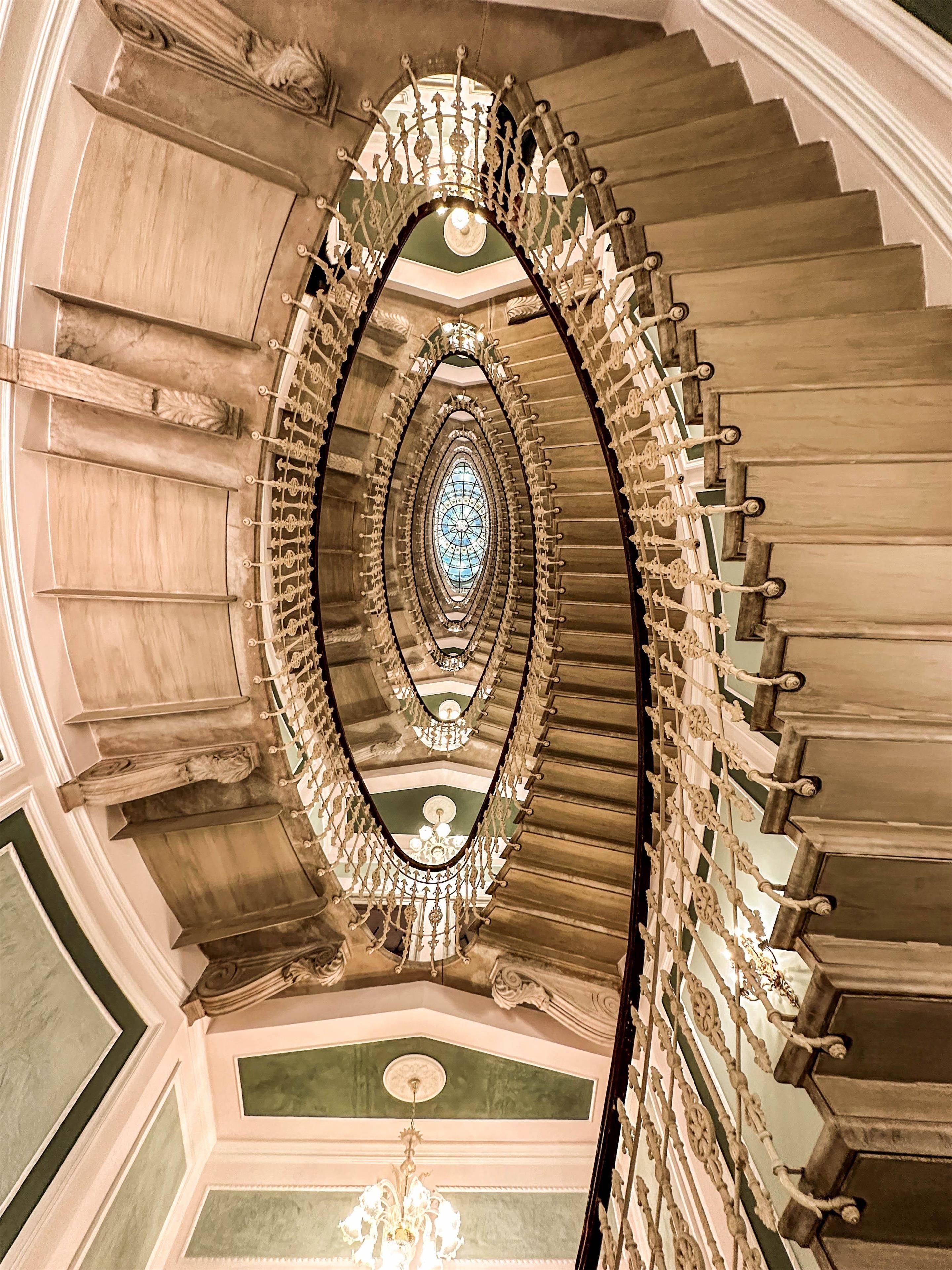 A grand staircase with ornate railings and a central glass window.