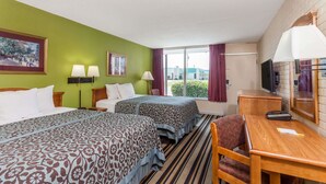 A hotel room with two beds, a desk, a chair, a TV, and a window with curtains. - Days Inn by Wyndham Jackson (Jackson)