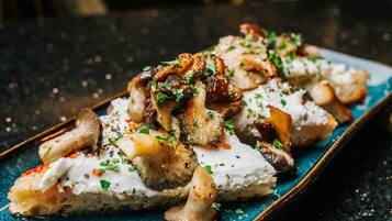 A dish with mushrooms and herbs on a blue plate.