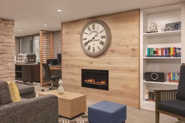 Un salon moderne avec une cheminée, une grande horloge murale et une bibliothèque.