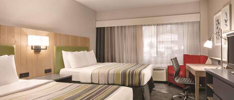 A hotel room with two beds, a desk, a chair, a lamp, and a large window with curtains.