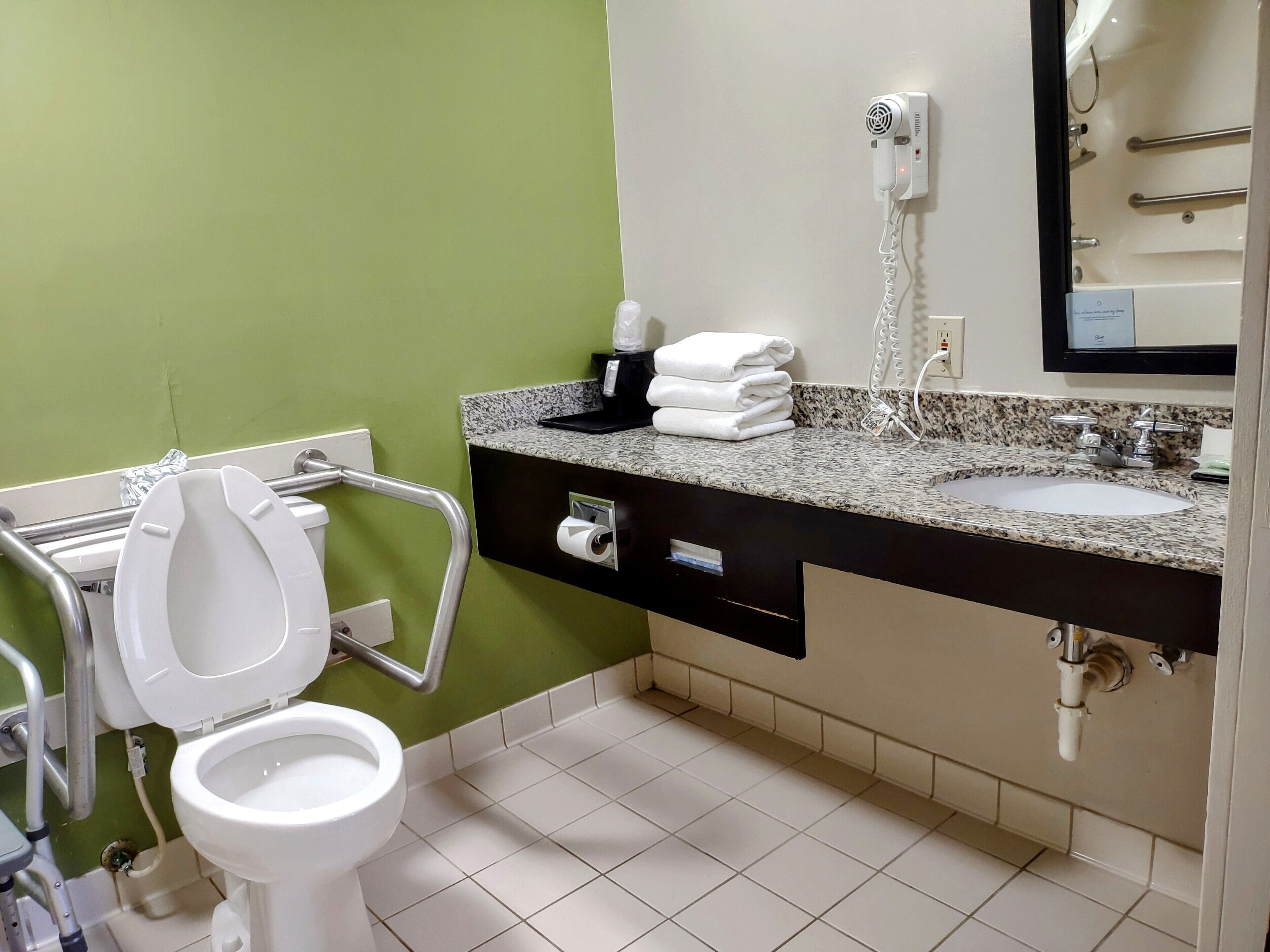 A bathroom with a white toilet, a sink, and a mirror.