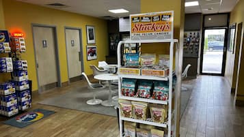 A store interior with a display of Stuckey's Pecan Candies, a gift shop, and a parking area visible through the doorway.