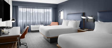 Une chambre d’hôtel équipée d’un lit, d’un bureau, d’une chaise et d’un téléviseur.