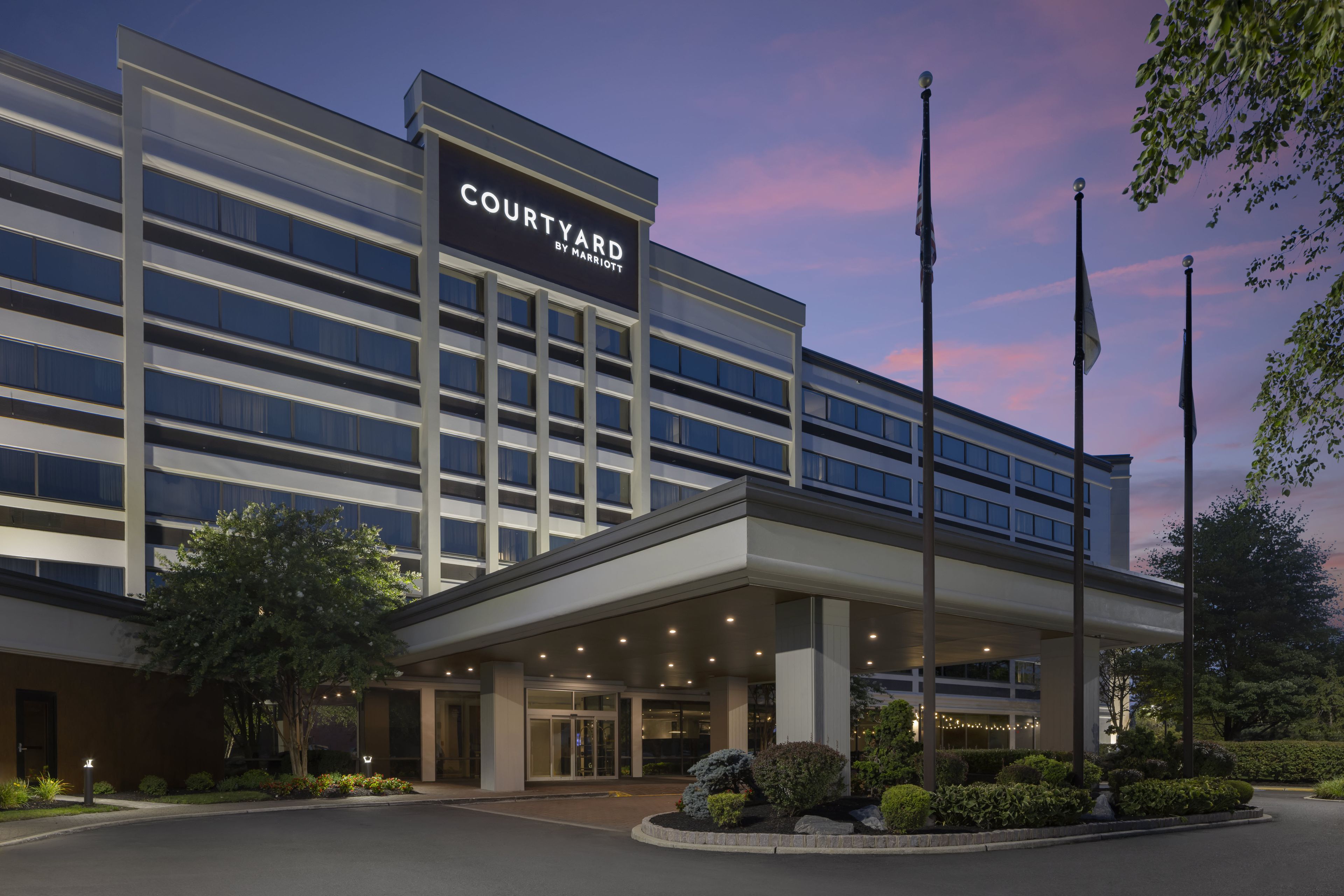 A Courtyard by Marriott hotel with a modern facade, multiple floors, and a well-lit entrance.