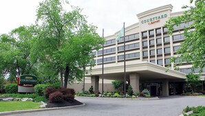 L’entrée d’un hôtel Courtyard Marriott, avec un jardin aménagé et une enseigne.