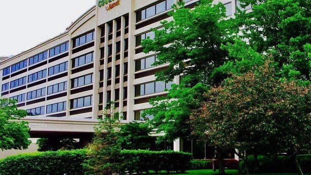 Un hôtel à plusieurs étages, doté d’une façade sobre, de grandes fenêtres et d’une enseigne indiquant « Courtyard by Marriott ».
