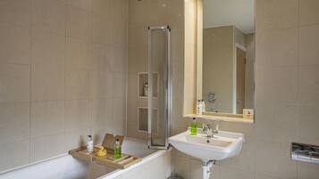 A bathroom with a bathtub, a shower, and a sink.