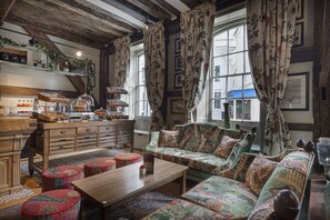 Ein gemütliches Zimmer mit einer hölzernen Bank, einem Sofa und einem Tisch mit einer Vitrine.