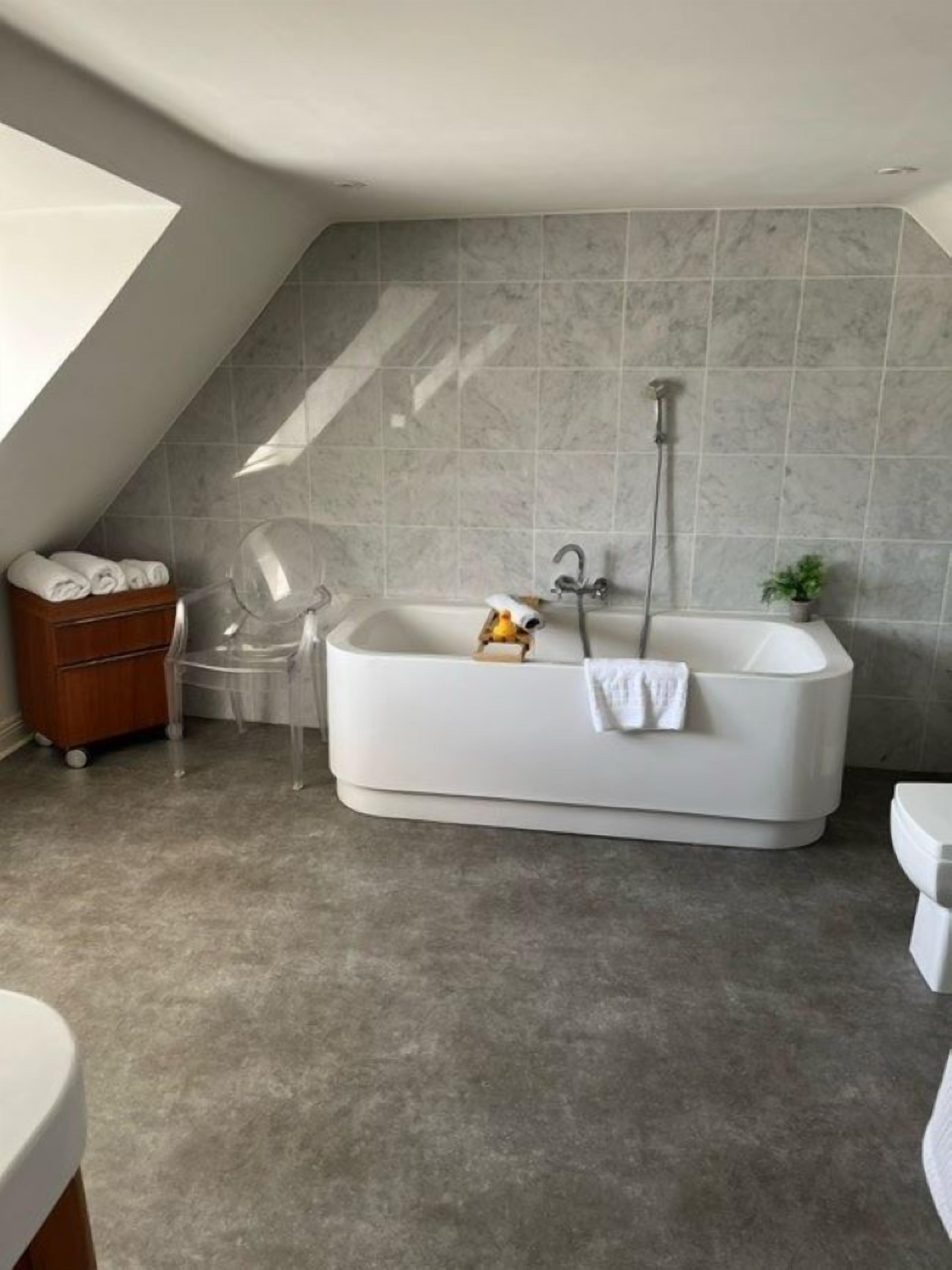 deluxe suite | bathroom | eco-friendly toiletries, hair dryer, bathrobes, slippers