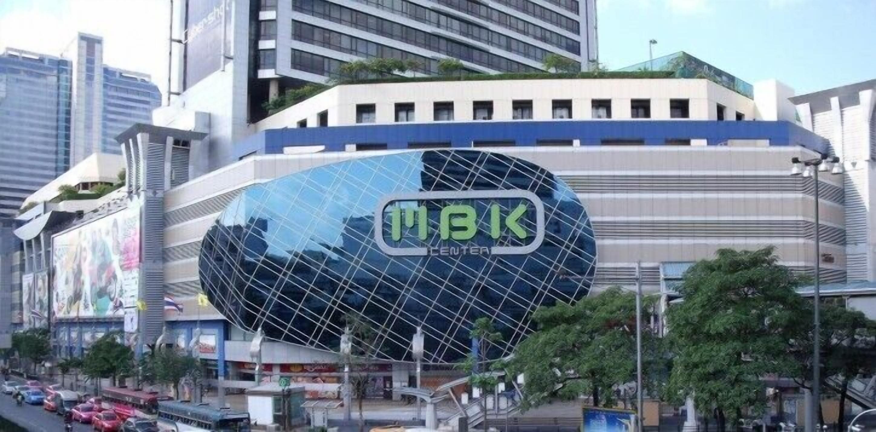 A modern building with a distinctive glass facade and a large sign reading "MAIK ENTER".