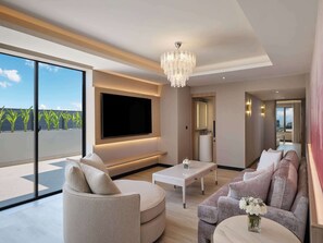 Relax in this stylish living room with a large flat-screen TV, comfortable seating area, and city views.