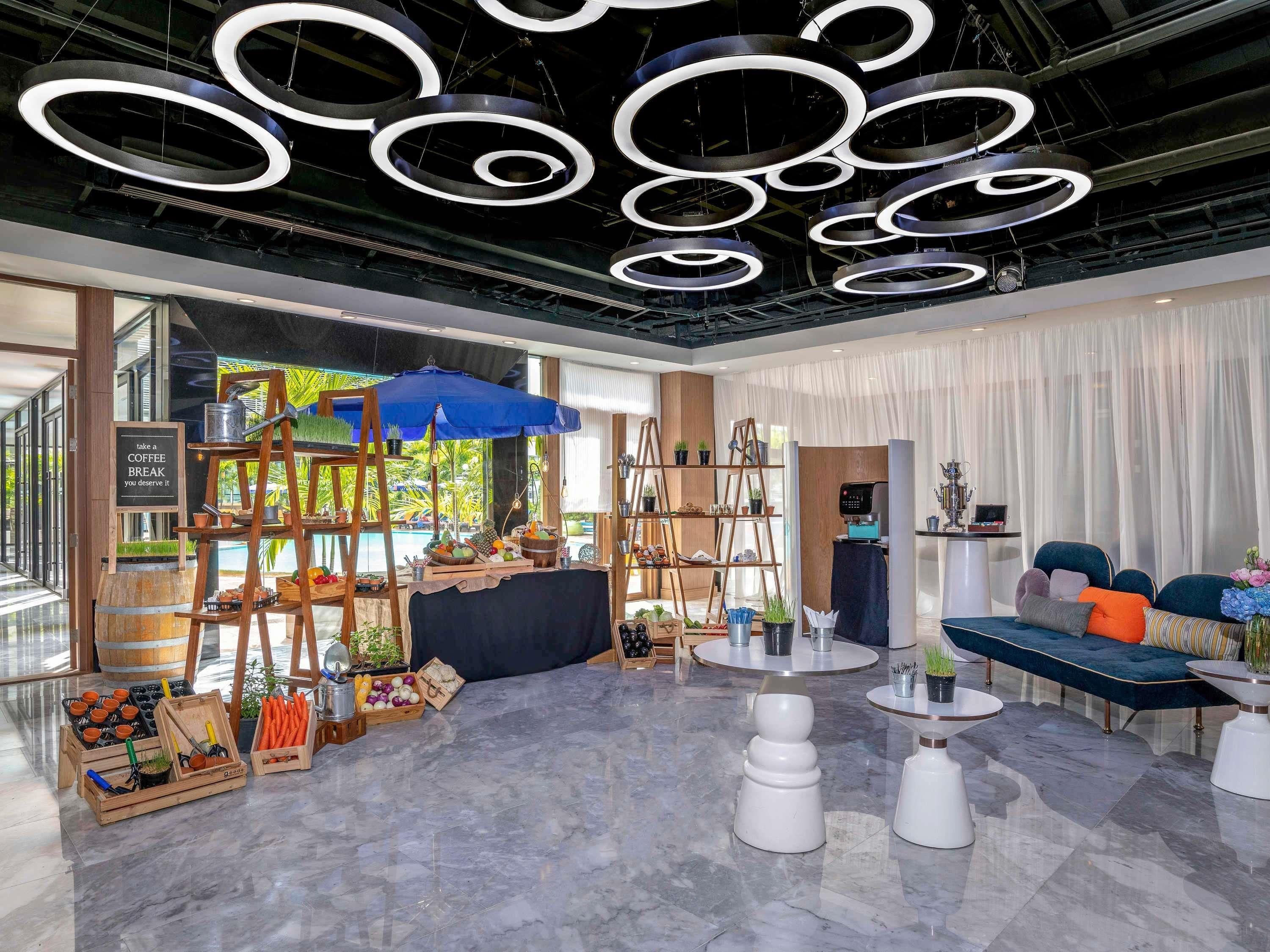 Un interior moderno con estación de café, zona de estar e iluminación decorativa.