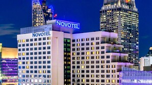 Un hotel Novotel con fachada moderna, varios pisos y un letrero destacado.