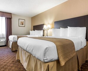A hotel room with a large bed, two bedside tables, a lamp, and a framed picture on the wall.