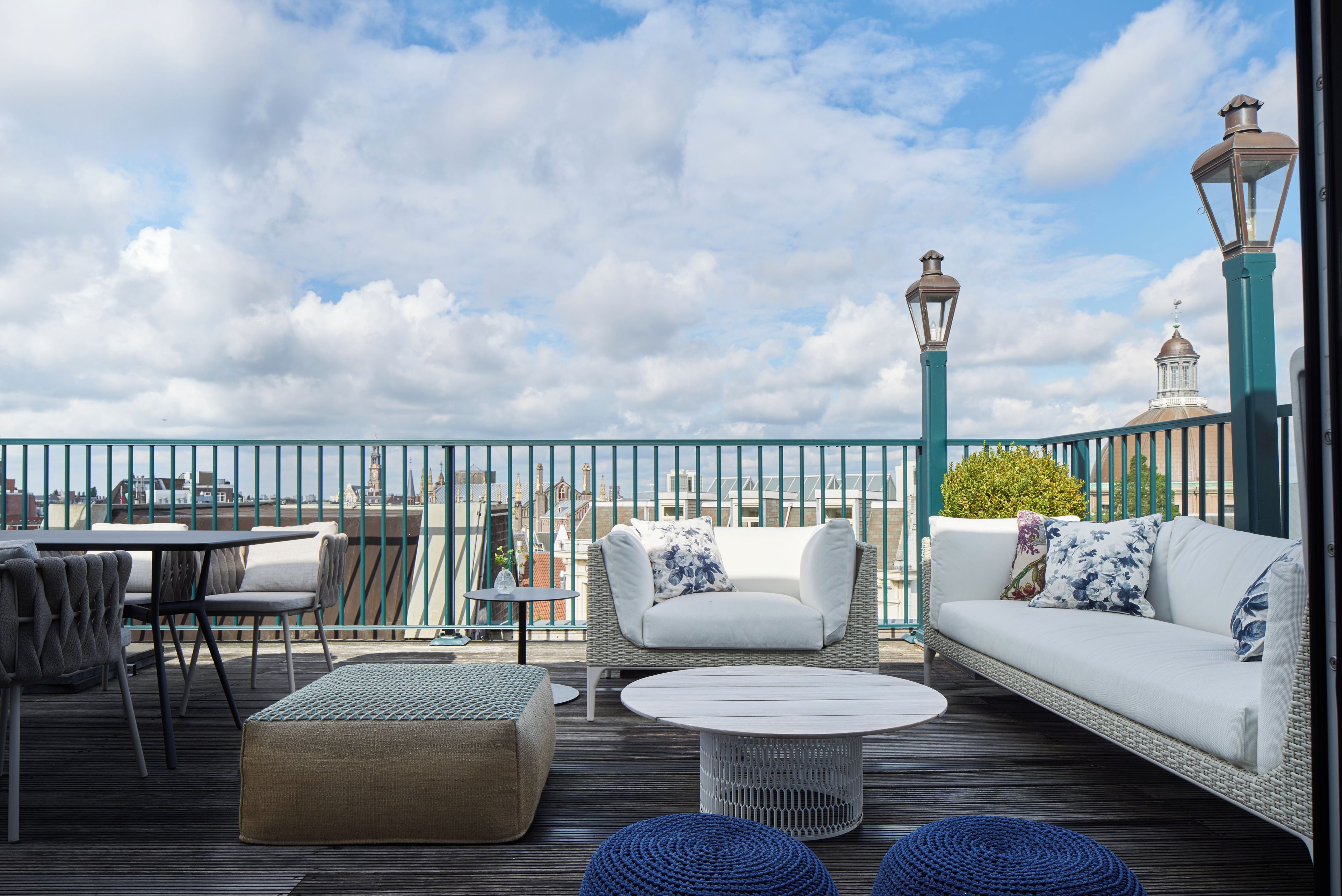 Une terrasse sur le toit avec des sièges extérieurs, une vue sur les toits de la ville et une lanterne décorative.