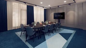 Sala de conferência com uma tela grande exibindo 'DeWitt Amsterdam' e uma mesa montada para uma reunião.