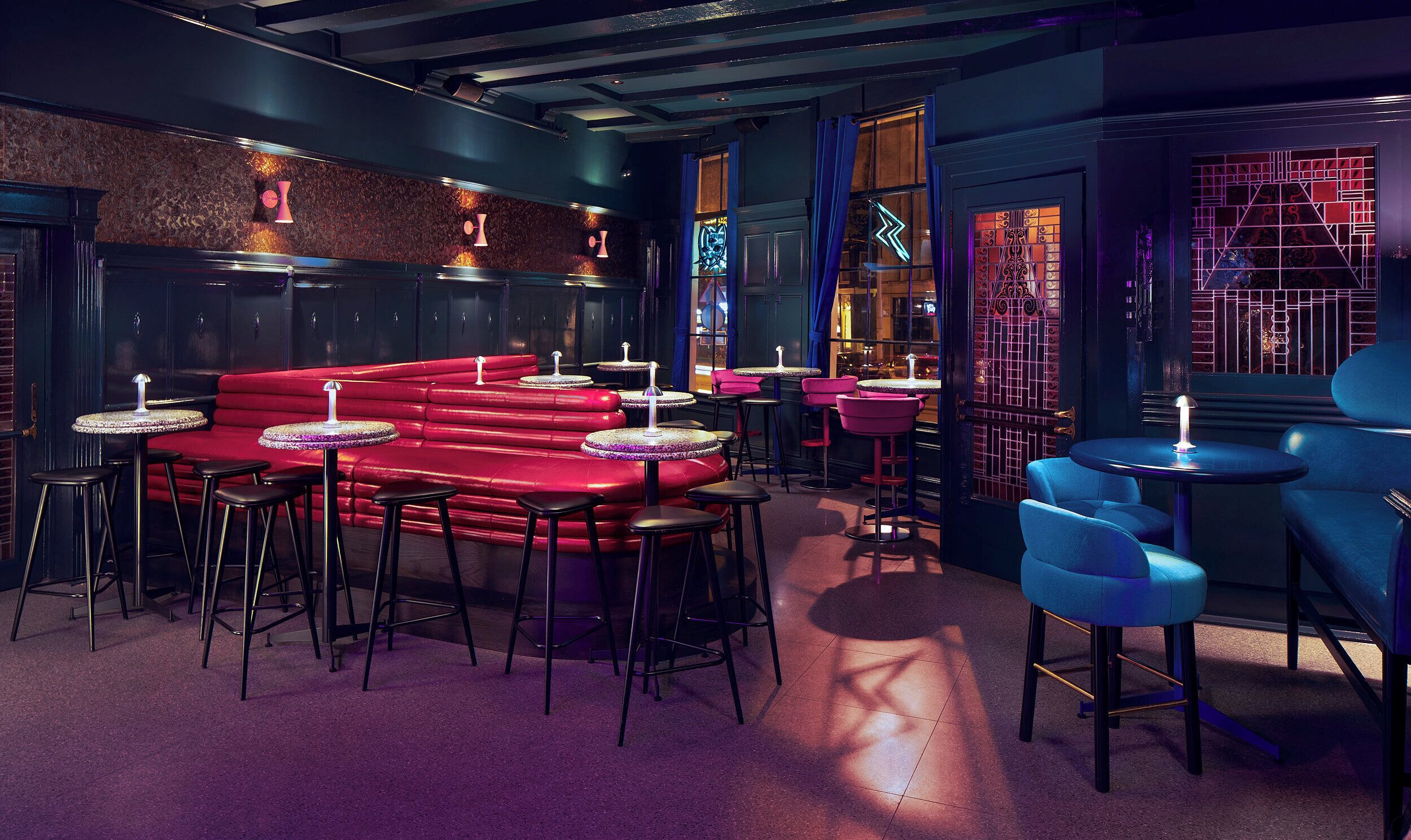 A bar area with red seating, black stools, and blue chairs.