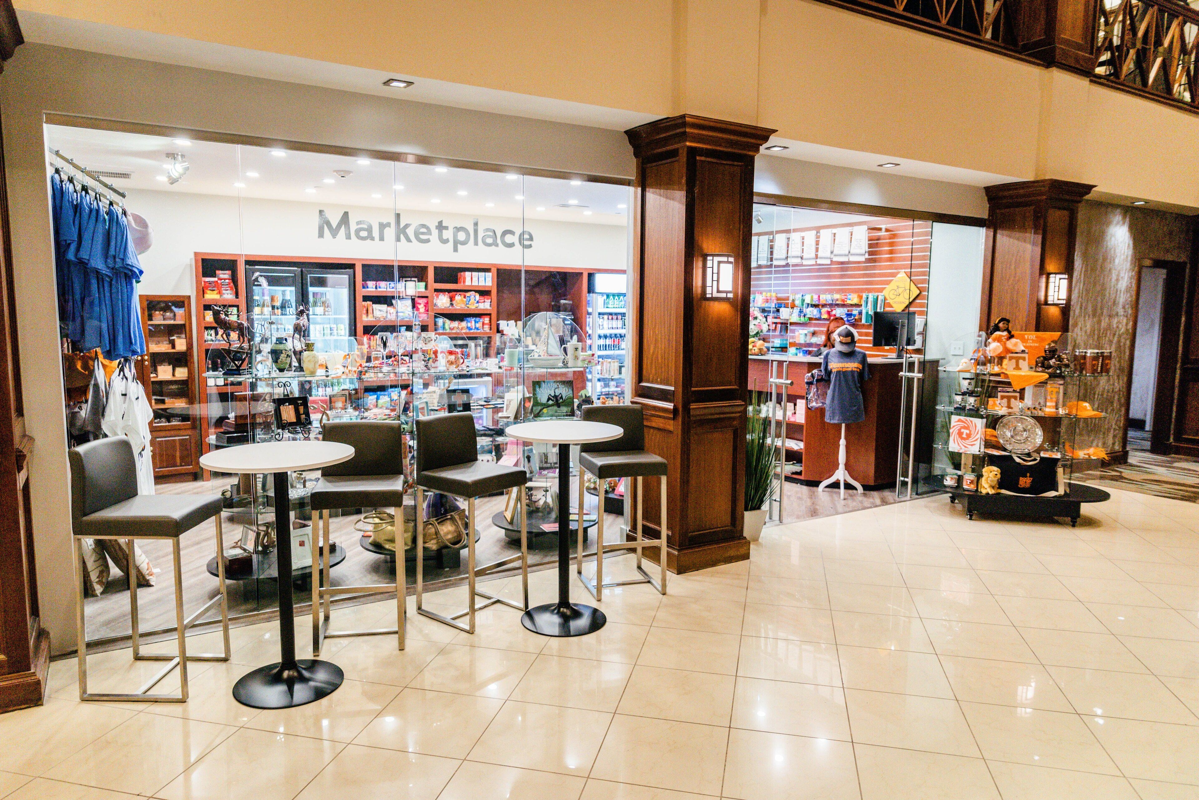 Um centro comercial com loja Marketplace, áreas de estar e exposição de diversos produtos.