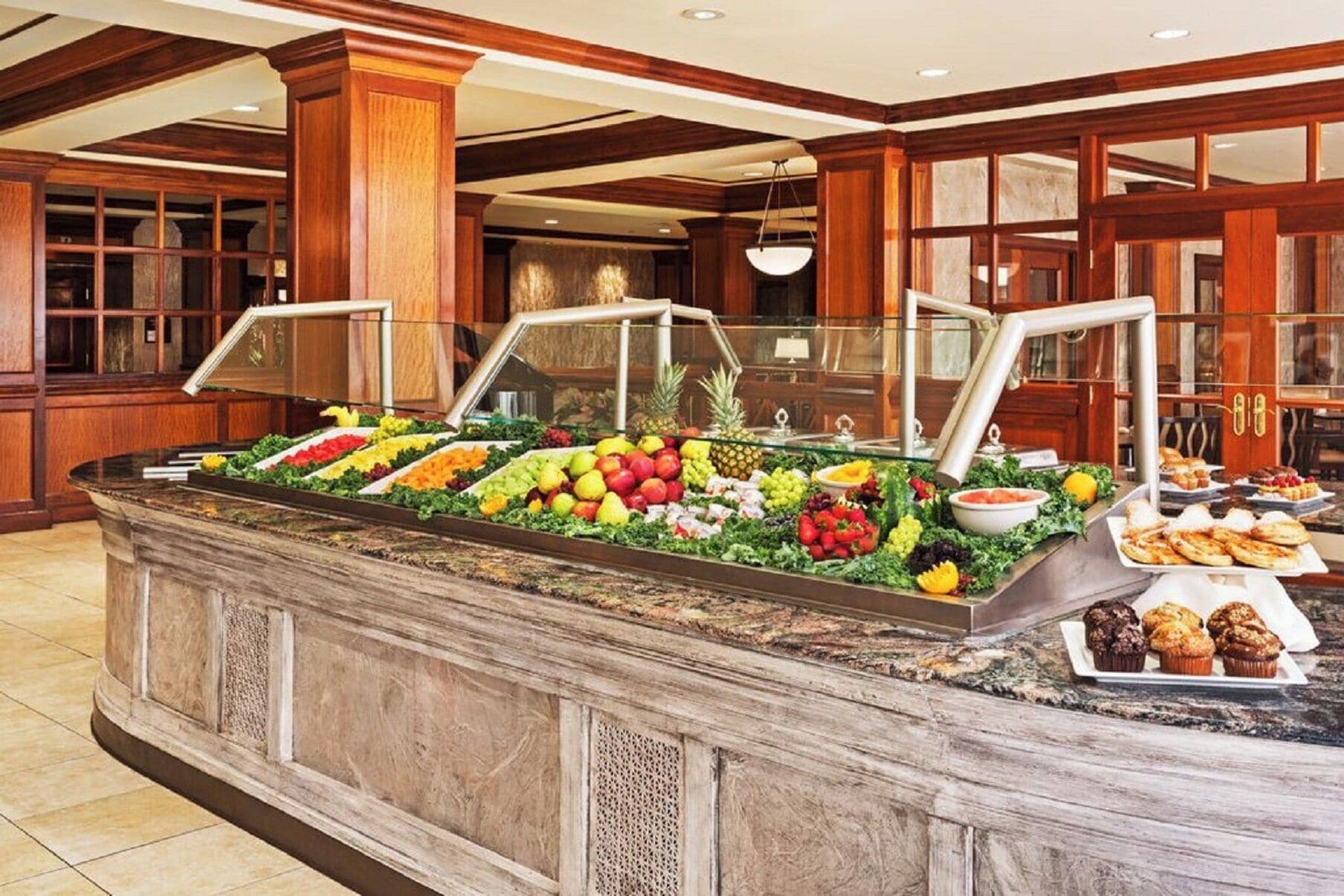 A buffet with various fruits and pastries.
